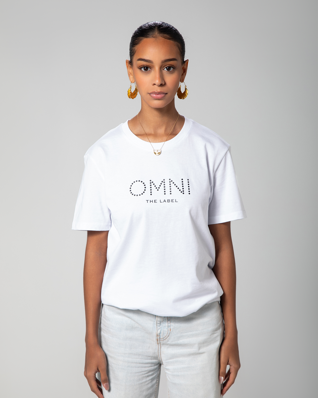 Front view of model wearing minimalist white T-shirt from Omni The Label with subtle branding—perfect for casual wear KSA UAE Qatar
