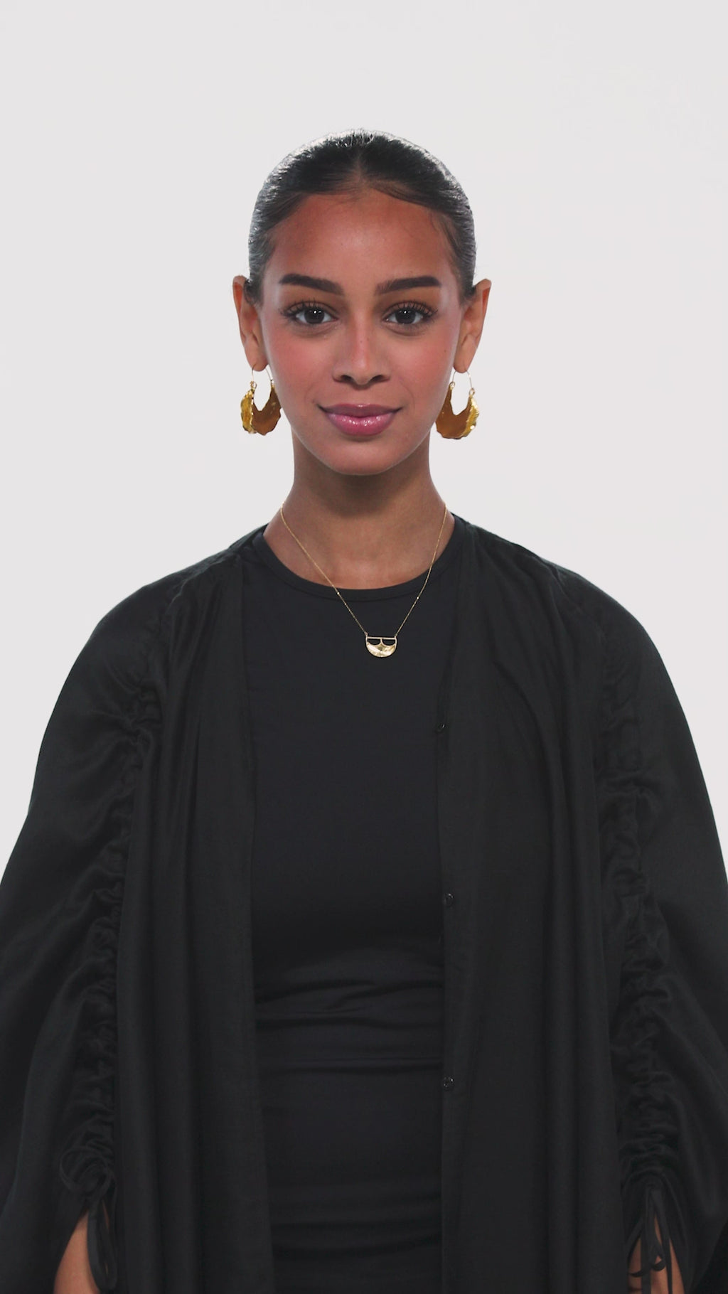 a black abaya with adjiustable sleeves in black with arabic caligraphy embroidered on the back by omni the label