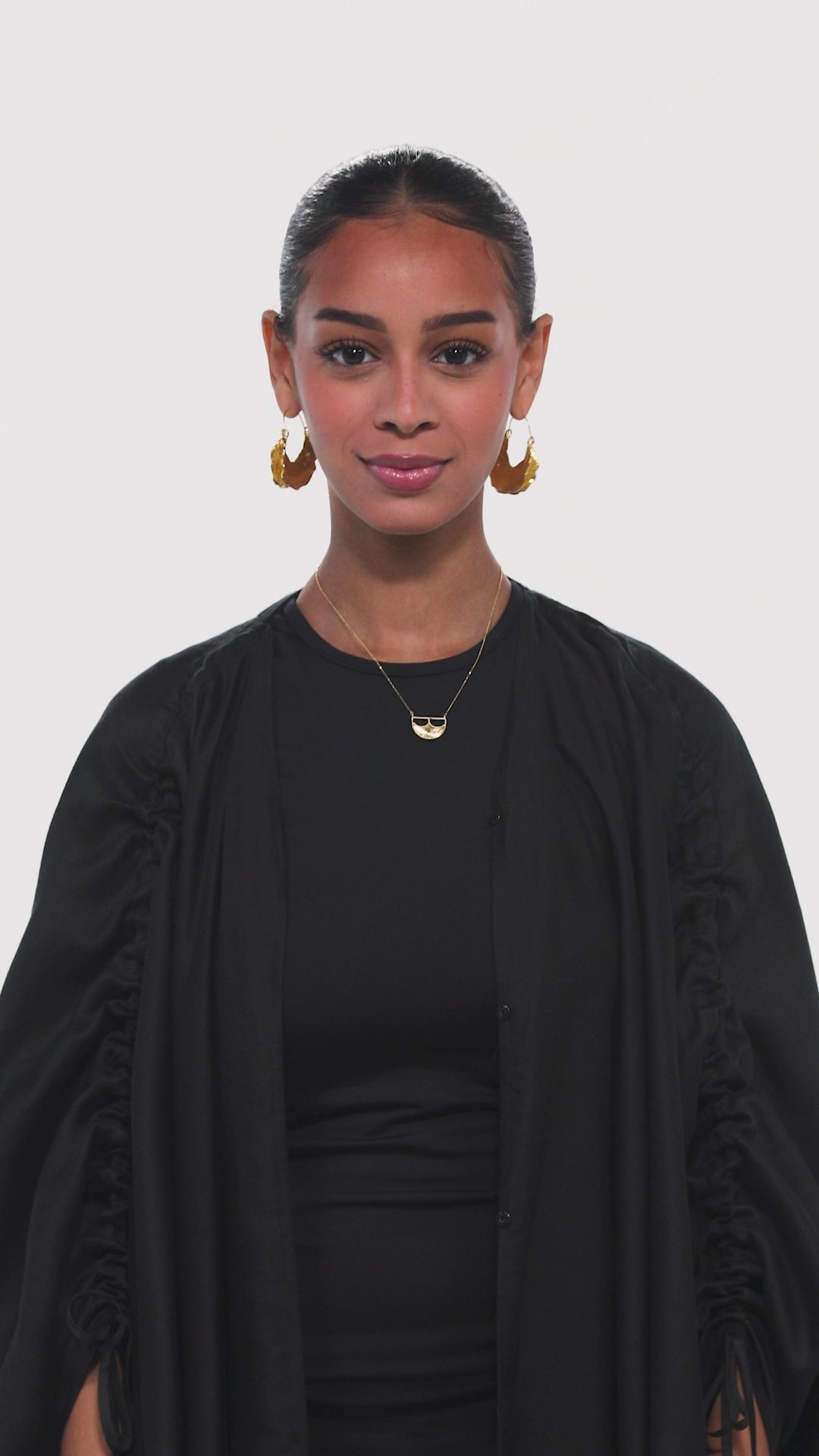a black abaya with adjiustable sleeves in black with arabic caligraphy embroidered on the back by omni the label