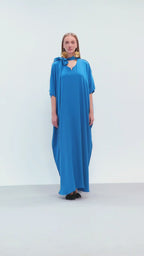 Model walking in royal blue embroidered maxi dress with tie neckline for Omni The Label campaign targeting luxury modest fashion in UAE Qatar KSA