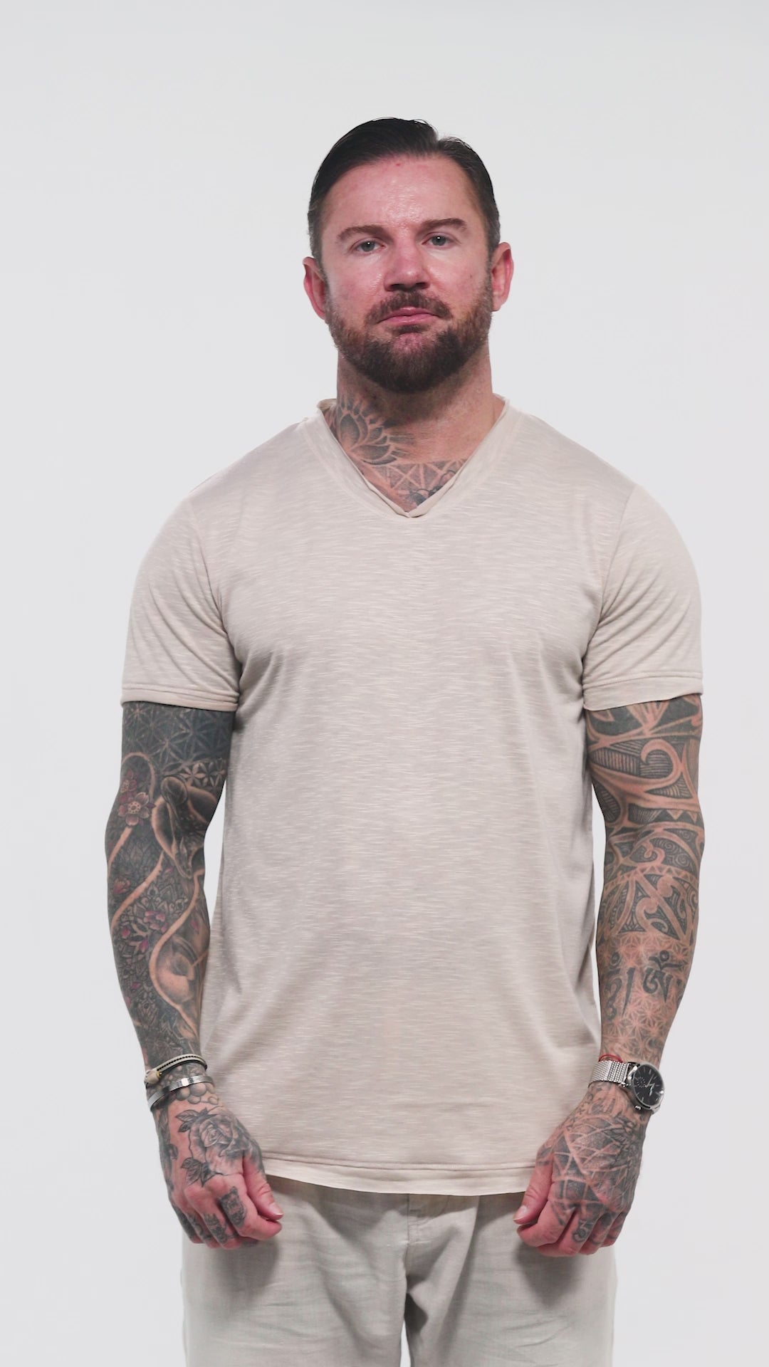 Male model  in the Marbella nude T-shirt by Omni The Label with Arabic embroidery reading this too shall pass shown in motion to highlight soft lightweight slub jersey fabric ideal for UAE KSA Qatar
