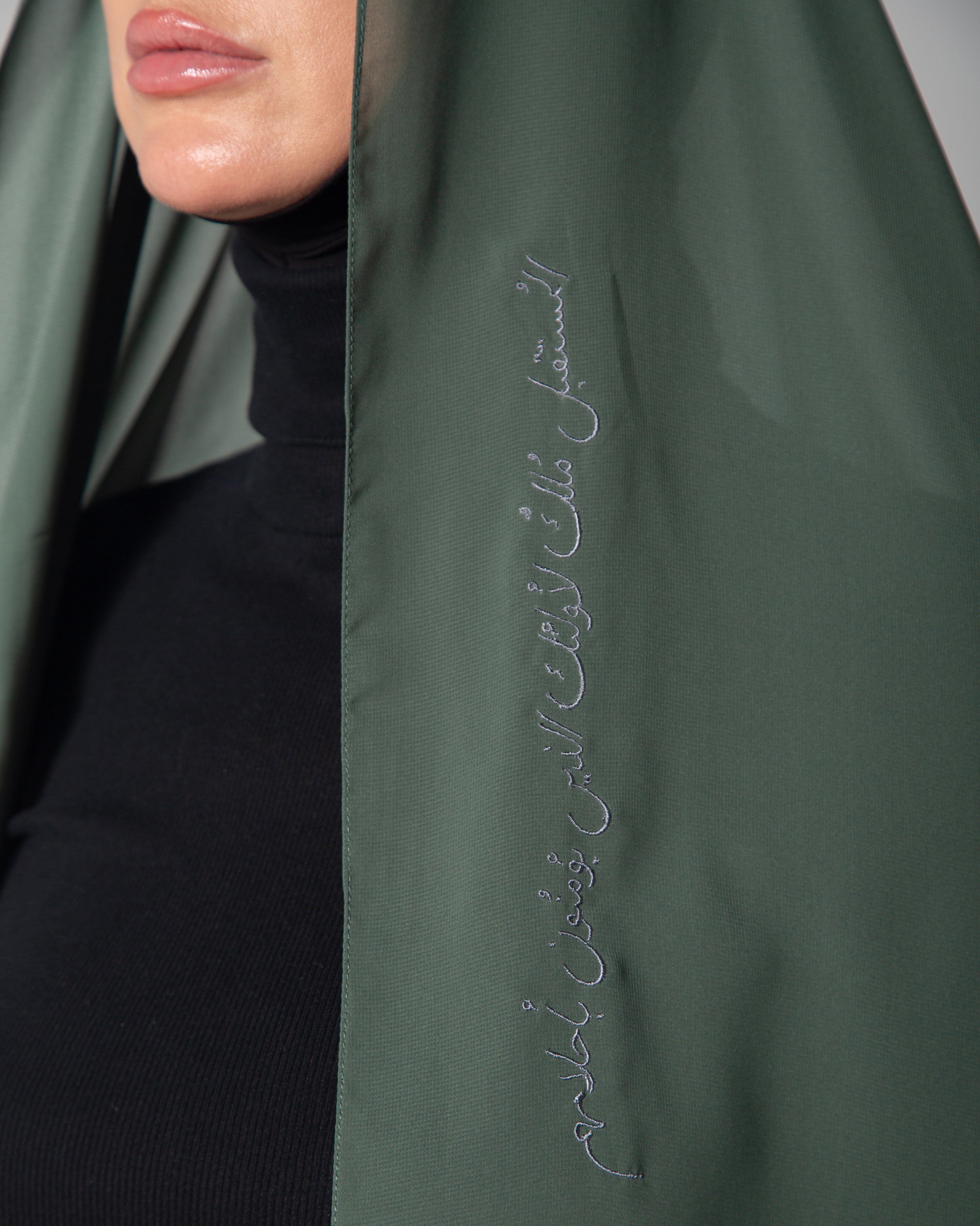 A woman wearing a light green scarf with dark gray embroidery  KSA UAE Qatar