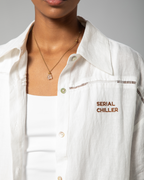 Model wearing white short-sleeve linen shirt with dropped shoulders, designed for casual elegance and effortless layering.UAE, KSA, Qatar