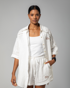 White linen top styled open over a tank top, highlighting the shirt’s airy construction and loose-fit design.UAE, KSA, Qatar