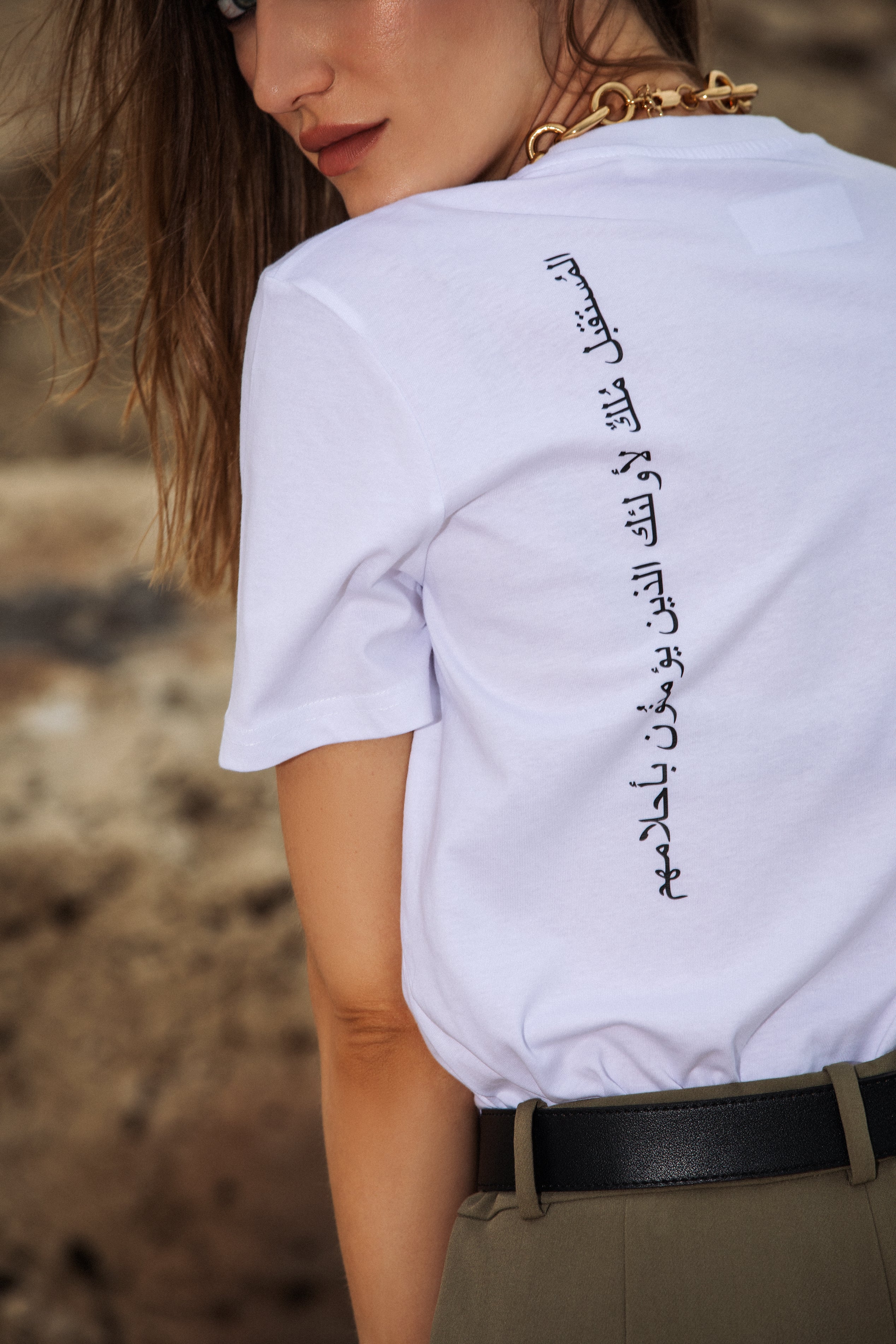 Outdoor styling of Omni The Label’s statement T-shirt with Arabic print—designed to inspire  Qatar, UAE, and Saudi Arabia