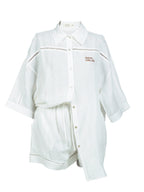 Close-up of Omni The Label’s white linen shirt featuring the “Serial Chiller” embroidery in fine script, highlighting the relaxed and playful summer aesthetic.UAE, KSA, Qatar