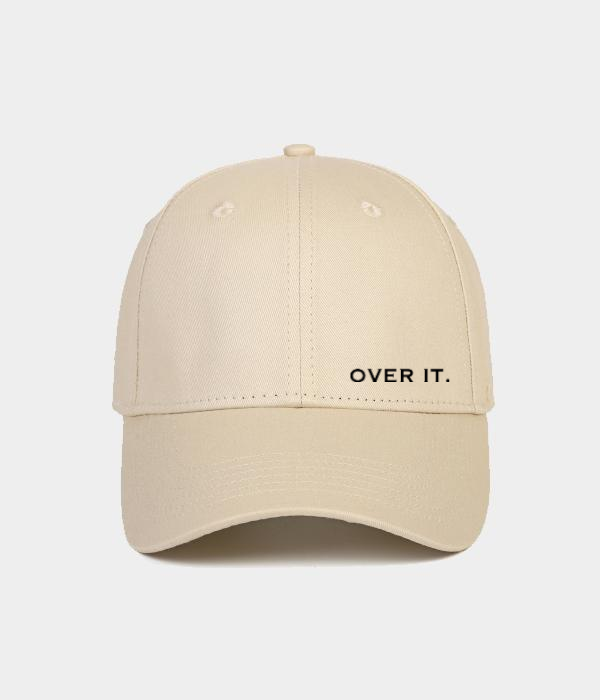 Over It beige baseball cap by Omni The Label with bold “Over It” print on the front panel