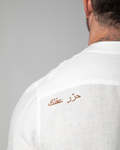 Close-up of Arabic embroidery reading "Free Your Mind" on the white linen shirt by Omni The Label – UAE, KSA, Qatar
